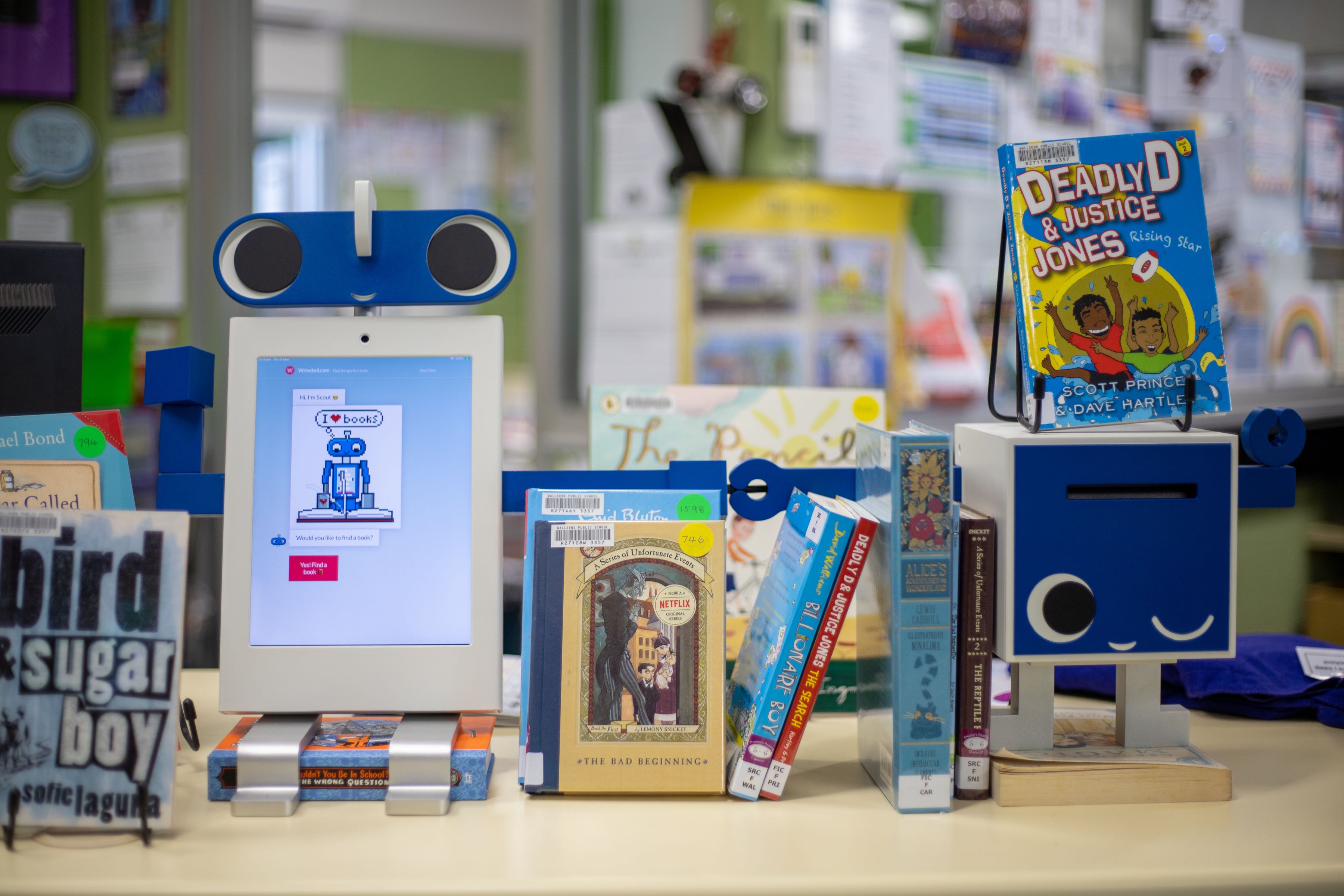 A Huey the Bookbot kiosk in a school library with an assortment of children's books